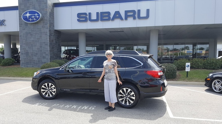 Kim in front of her first Subaru - a 2017 Outback.jpg