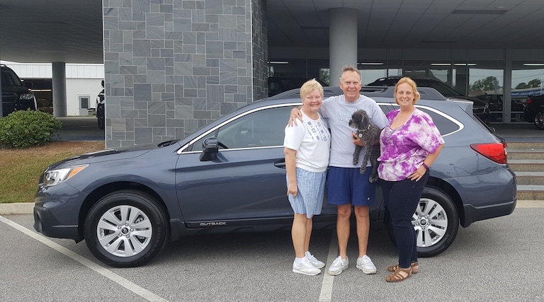 William, Jay and pup Andy with Sales Advisor Kristen in front of their new 2017 Outback.jpg
