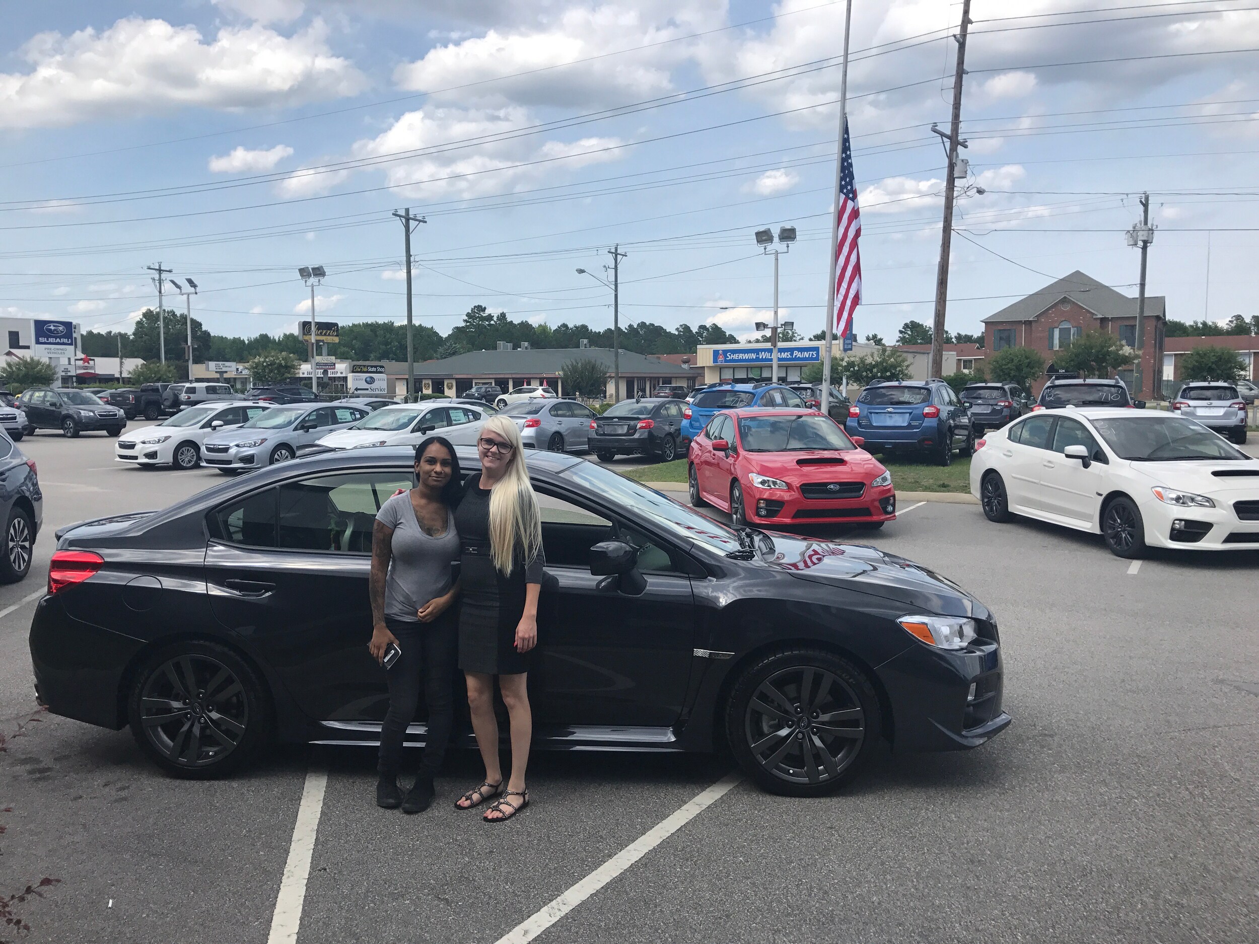 Trisha in front of her dream car - the 2017 WRX - with Sales Advisor Ava.JPG