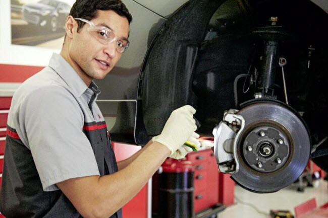 Toyota Service Tech Working on Brakes Toyota Service Tech Working on Brakes