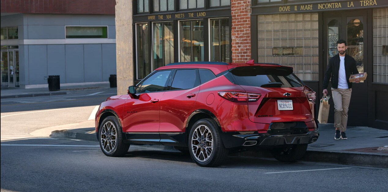 2023-chevy-blazer-3.PNG A red 2023 Chevy Trailblazer parked on a city street showing the profile and back of the vehicle