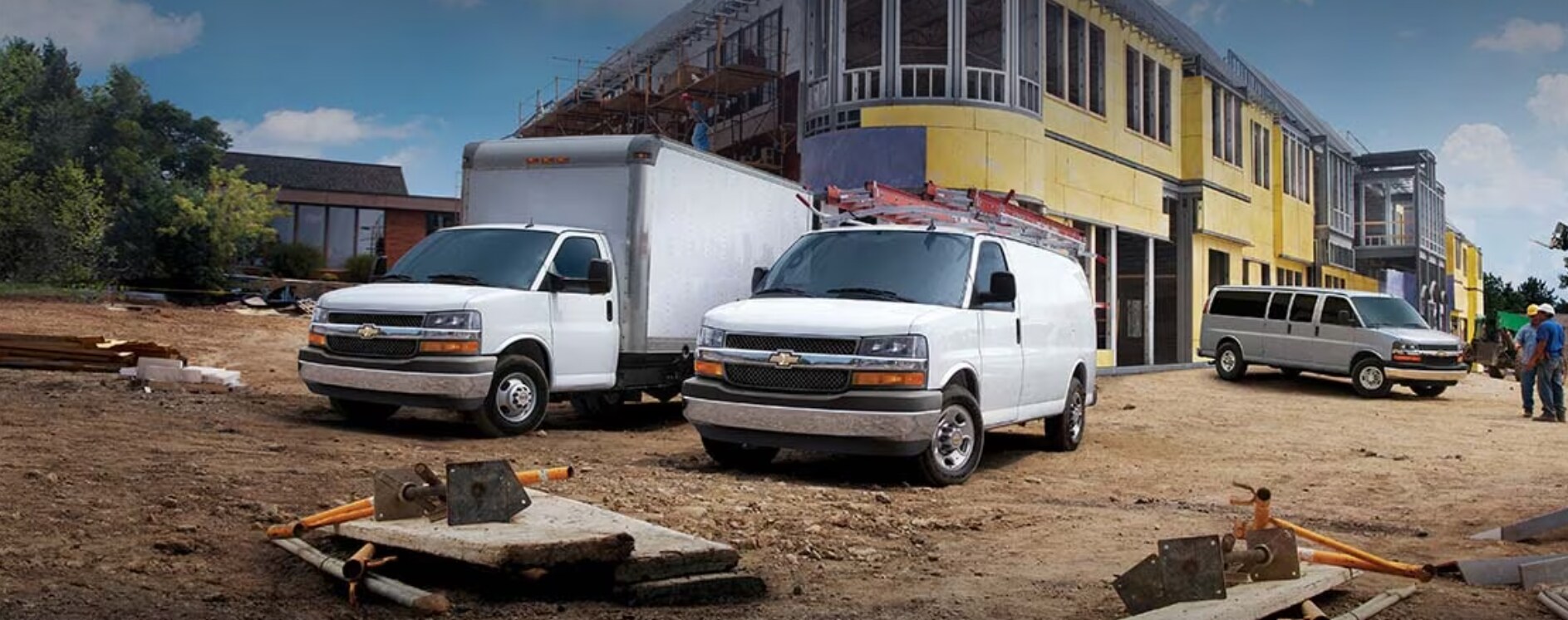 2023-chevy-express-1.PNG three 2023 Chevy Express Vans and a Cutaway Van sit parked at different angles on a street