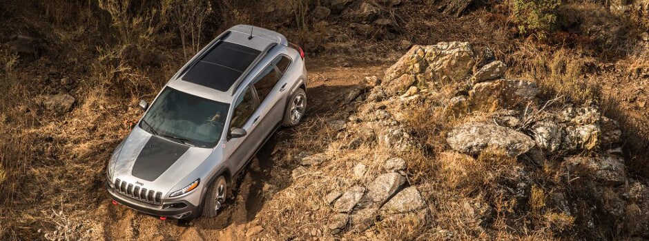 What Does Jeep Trail Rated Mean A 2018 Jeep Trail Rated Model Driving Down a Dirt Road