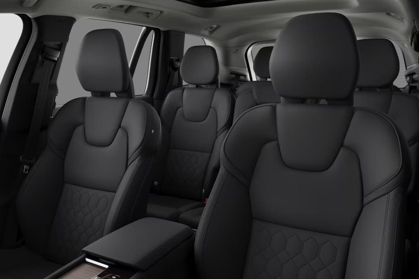Volvo XC90 Plug-In Hybrid interior featuring three rows of black seats with detailed stitching and a spacious cabin.