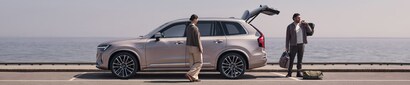 Volvo XC90 Plug-in Hybrid Ultra parked by the ocean with people loading luggage