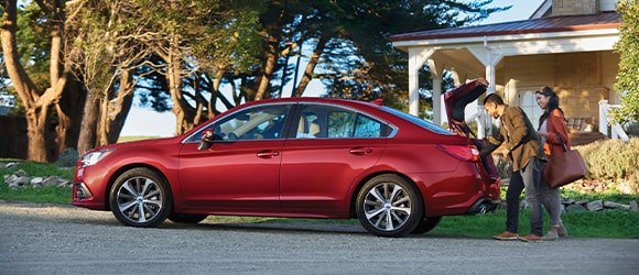Couple Loads Luggage into Trunk of Red subaru
