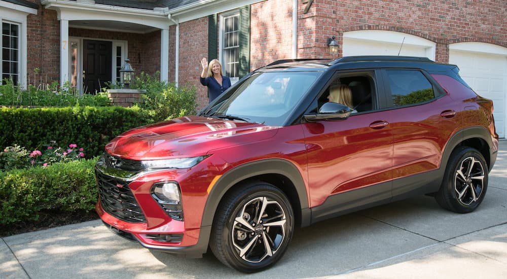 A red 2022 Chevy Trailblazer RS is shown from the side in a driveway after leaving a used Chevy …