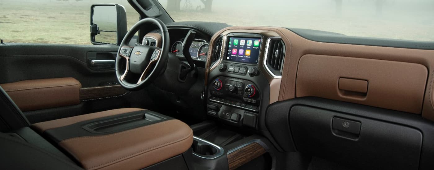 2023 Chevy Silverado 2500 HD Interior.jpg The black and brown interior of a 2023 Chevy Silverado 2500 HD shows the center console and steering wheel.