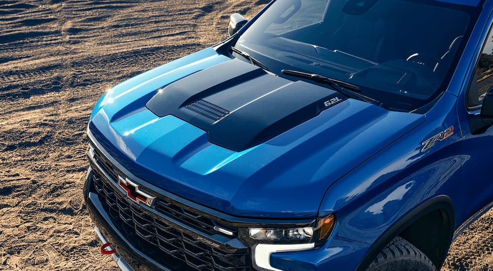 A close up of the front of a 2023 Chevy Silverado 1500 ZR2 is shown parked on a dirt lot.