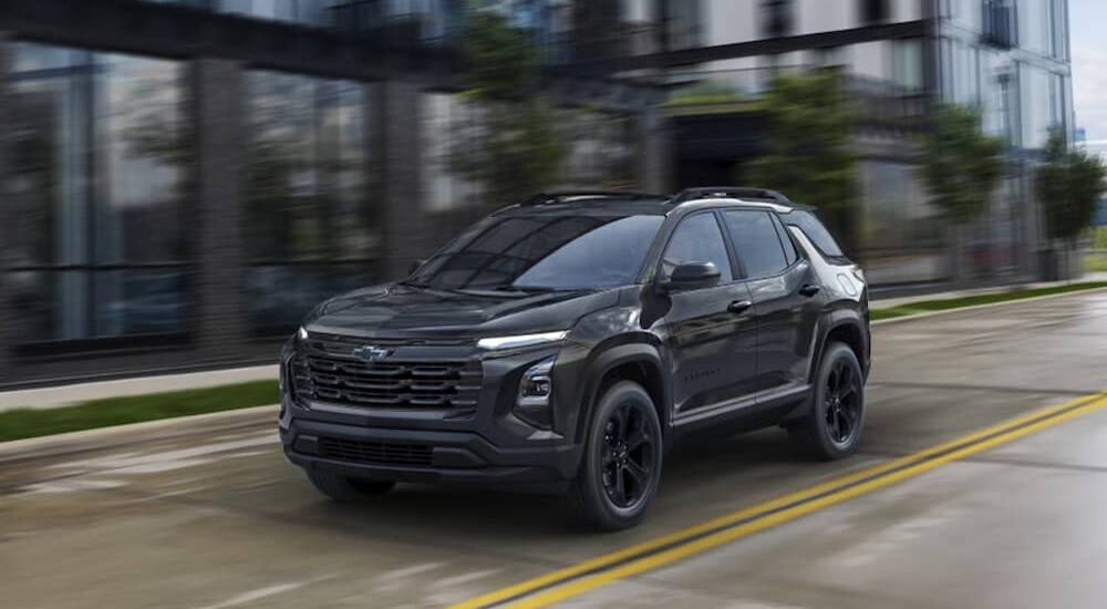 2025%20Chevy%20Equinox%20Midnight%20Edition%20-%20Black.jpg A black 2025 Chevy Equinox Midnight Edition is shown driving on a city street.