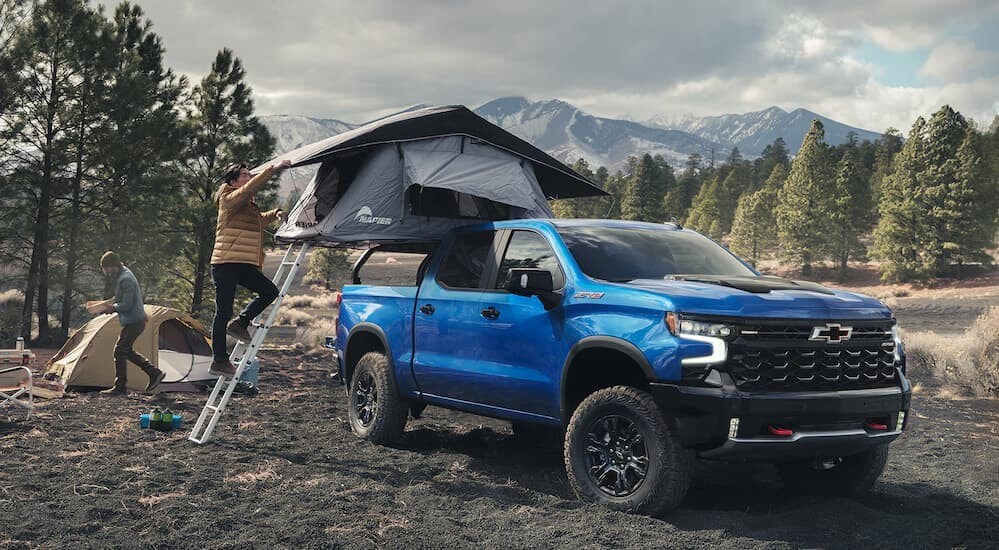 2025%20Chevy%20Silverado%201500%20-%20ZR2%20-%20Tent.jpg A blue 2025 Chevy Silverado 1500 ZR2 is shown parked on a campsite.