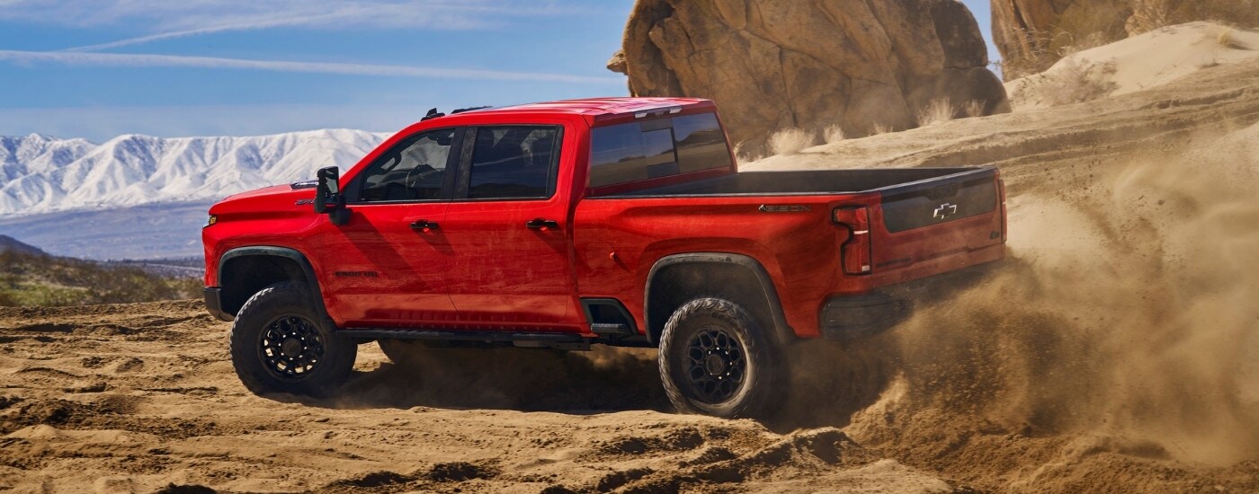 2025%20Chevy%20Silverado%202500%20HD%20ZR2%20Bison%20-%20Dust.jpg A red 2025 Chevy Silverado 2500 HD ZR2 Bison is shown off-road.