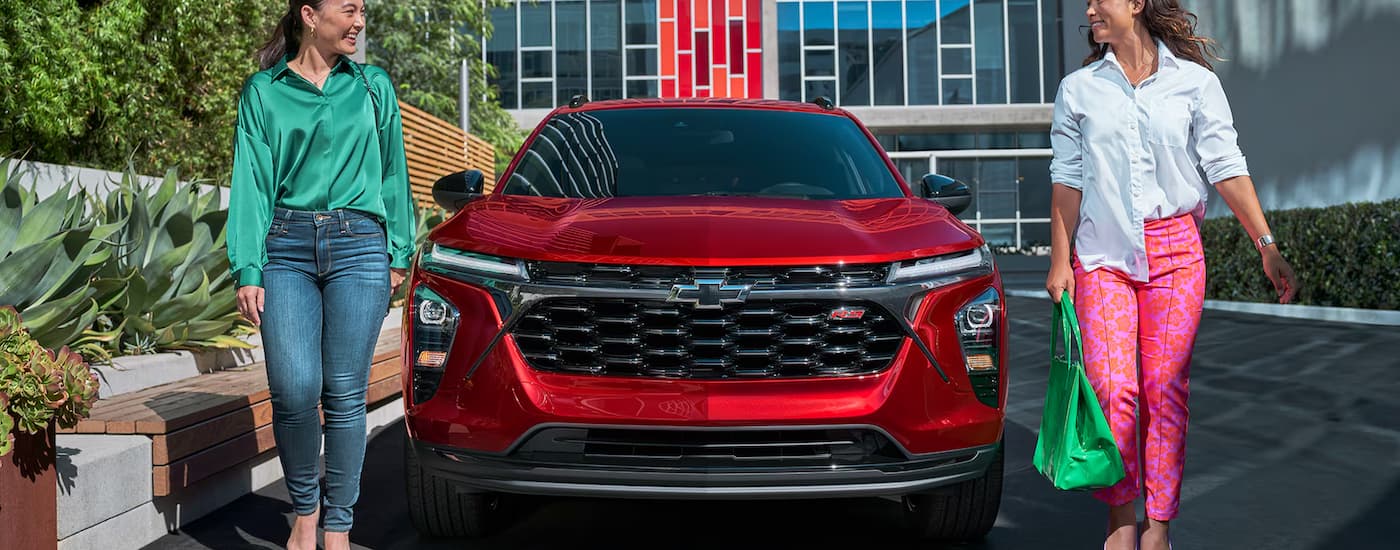 2025%20Chevy%20Trax%202RS%20-%20Red%20front.jpg Two people are walking next to the front of a red 2025 Chevy Trax 2RS.