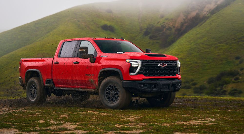 A red 2024 Chevy Silverado 2500HD ZR2 Bison is shown parked off-road.