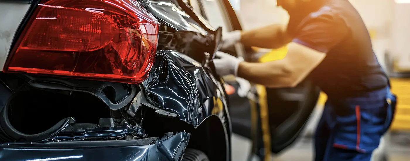GM-certified body technician performing structural collision repairs on a vehicle at Dave Gill Chevrolet in Columbus, OH