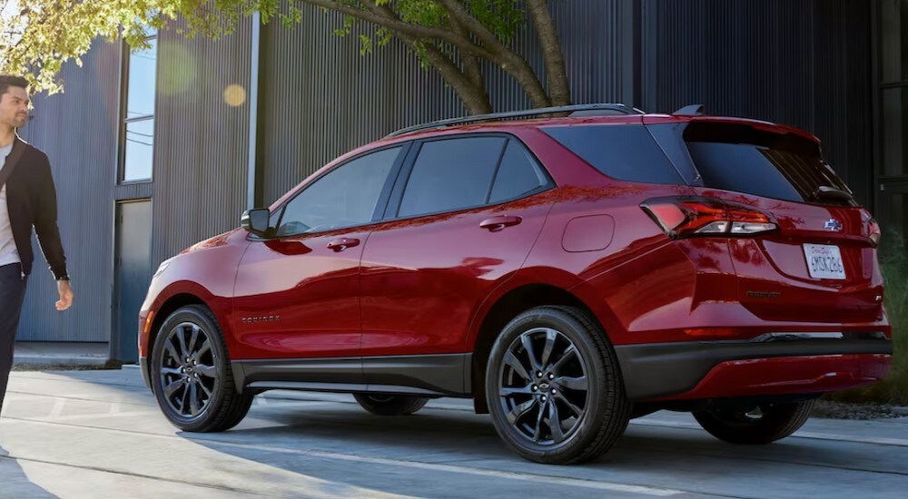 2024 Chevy Equinox- Person.jpg A person is shown walking near a red 2024 Chevy Equinox.