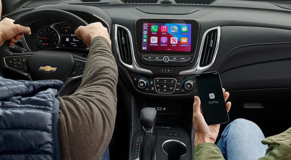 A person is shown using Apple Carplay in a 2023 Chevy Equinox.