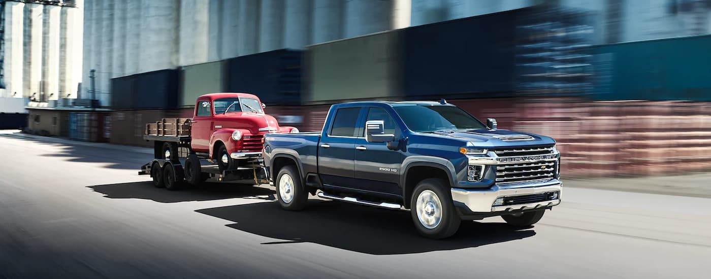 2023 Chevy Silverado 2500HD - Towing Red Truck.jpg A red 2023 Chevy Silverado 2500 HD is shown towing a red truck on a trailer.