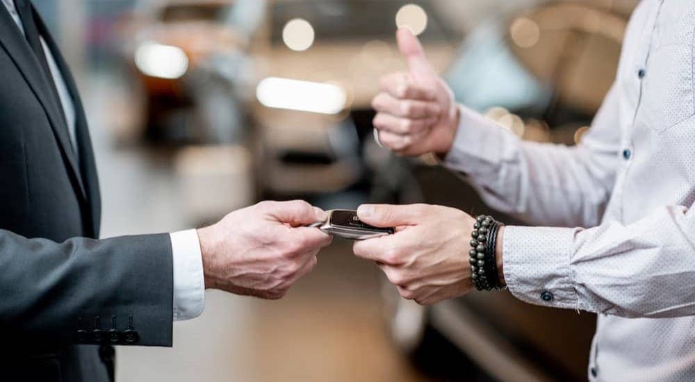 Two people are shown exchanging a key fob at a Pataskala Chevy dealer.