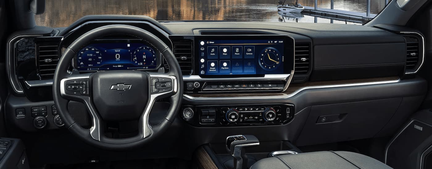 The black interior of a 2023 Chevy Silverado 1500 shows the steering wheel and center console.
