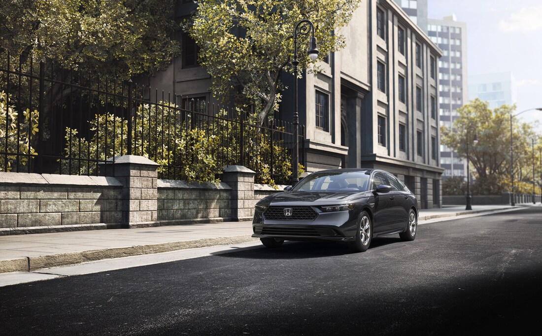 2023-Honda-Accord-LX-Sedan-L01.png dark gray Honda Accord driving past a stone wall with wrought iron
