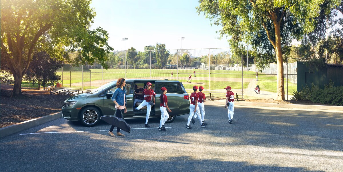 2022-Honda-Odyssey-Elite-Van-L04.png baseball team getting out of a dark gray Honda Odyssey minivan