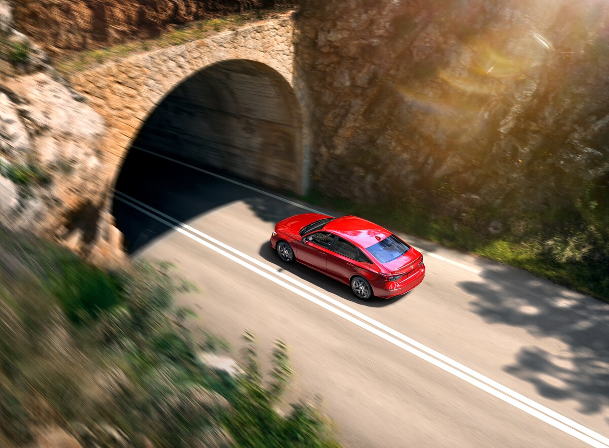 2022-Honda-Civic-Sport-Sedan-L01.png red Honda Civic sport sedan about to enter a mountain tunnel