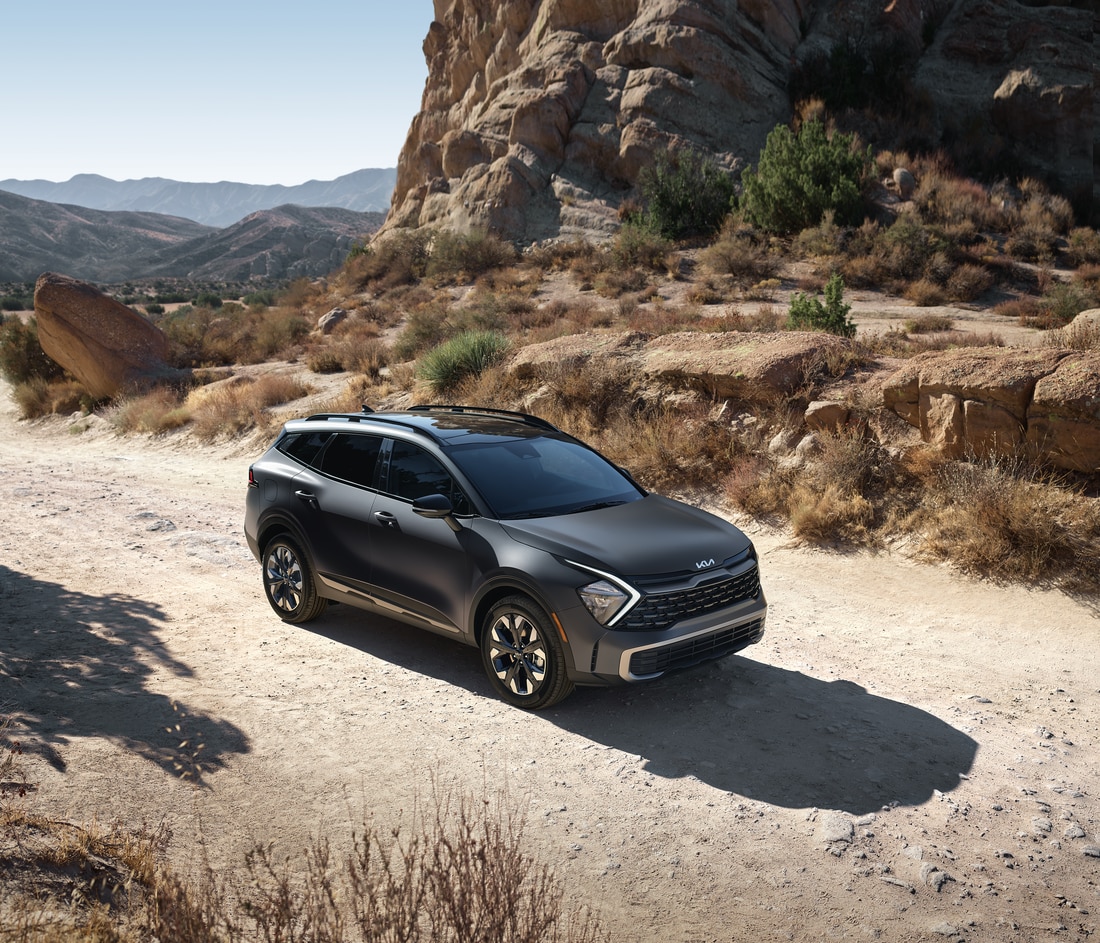 2023-KIA-SportagePlugInHybrid-Turbo-XLine-SUV-L02.png dark grey Kia Sportage Plug-In Hybrid parked on a desert trail