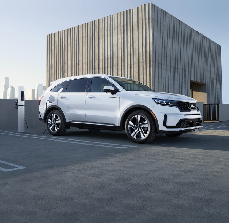 2022-KIA-SorentoPlugInHybrid-SXPrestige-SUV.png white Kia Sorento Plug-In hybrid SUV parked at a rooftop charging station