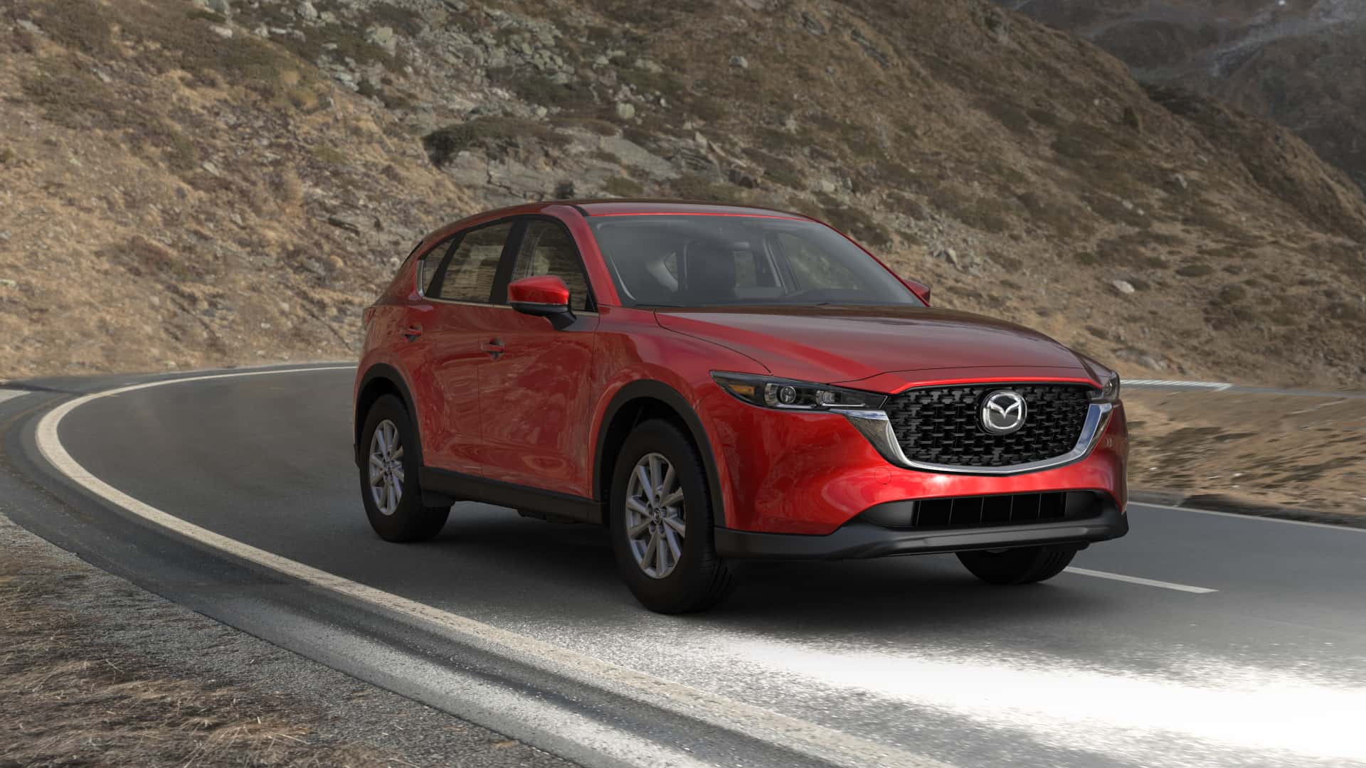 red Mazda CX-5 driving down high-walled desert road