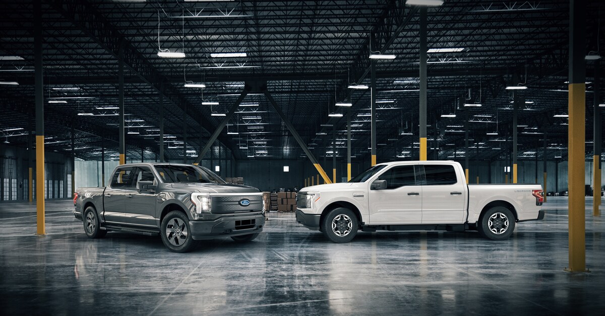 2022-Ford-Electric-Lineup-L01.png Ford Lightning electric trucks parked inside an empty warehouse
