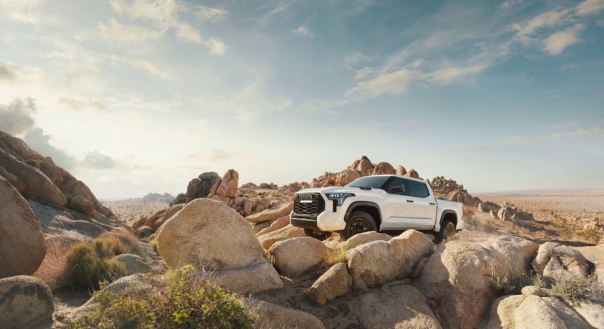 2022-Toyota-Tundra-TRDPro-CrewCab-Truck-L03.png white Toyota Tundra truck parked on desert rocks