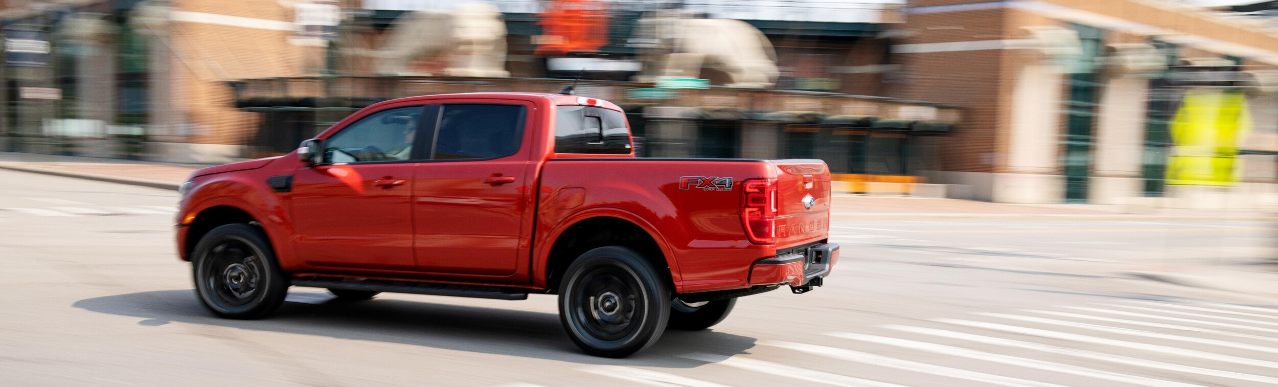 Red Ford Ranger driving through town