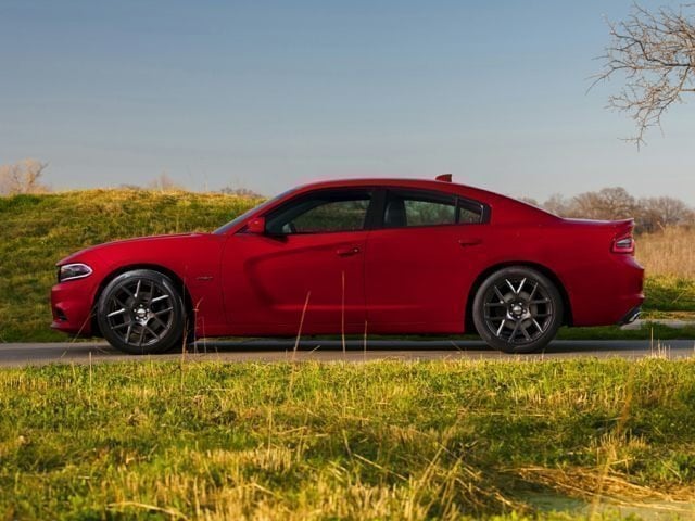 2017 Dodge Charger sedan red facing left on road surrounded by grass and hills.jpg