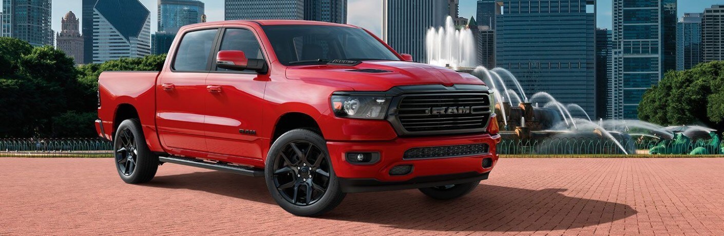 2020 Ram 1500 Laramie exterior shot with red paint color parked on a red brick platform in a park near an erupting fountain