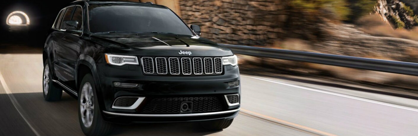2019 Jeep Grand Cherokee exterior front shot with black paint color exiting out of a tunnel_o.jpg