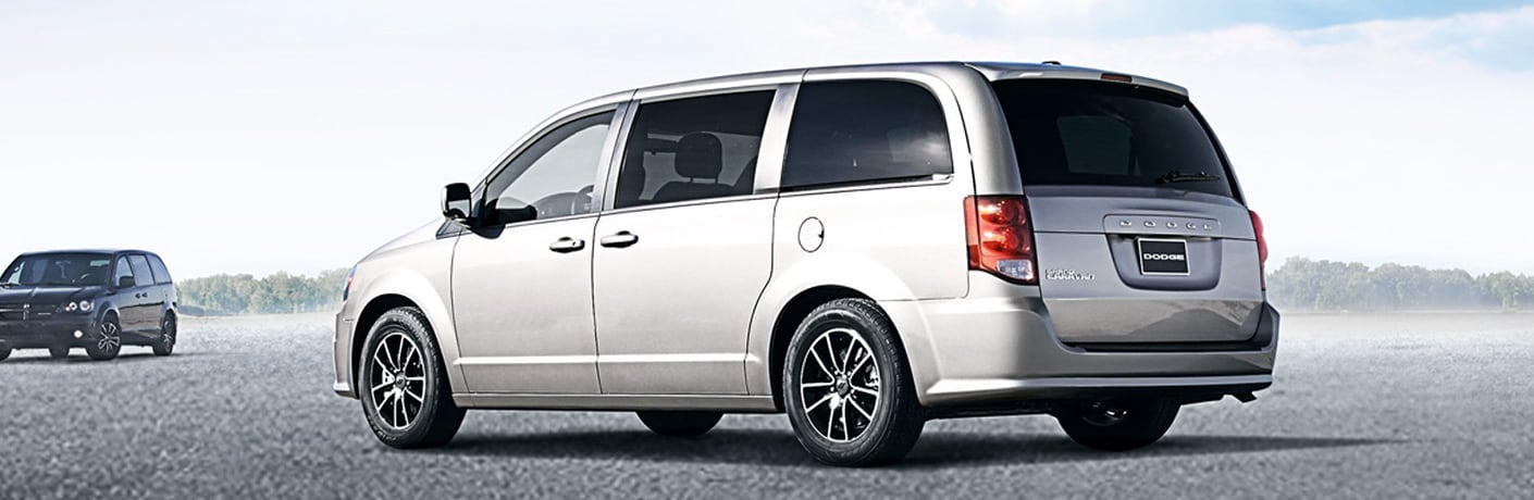 2019 Dodge Grand Caravan models in white and black exterior shot parked on a gravel plain