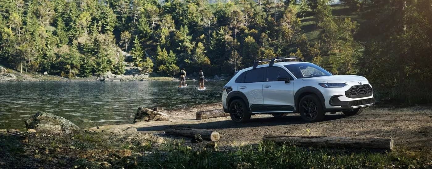 Honda SUVs for Sale - 2023 Honda HR-V Sport - Paddle.jpg One of the most popular Honda SUVs for sale, a white 2023 Honda HR-V Sport, is shown near a lake.