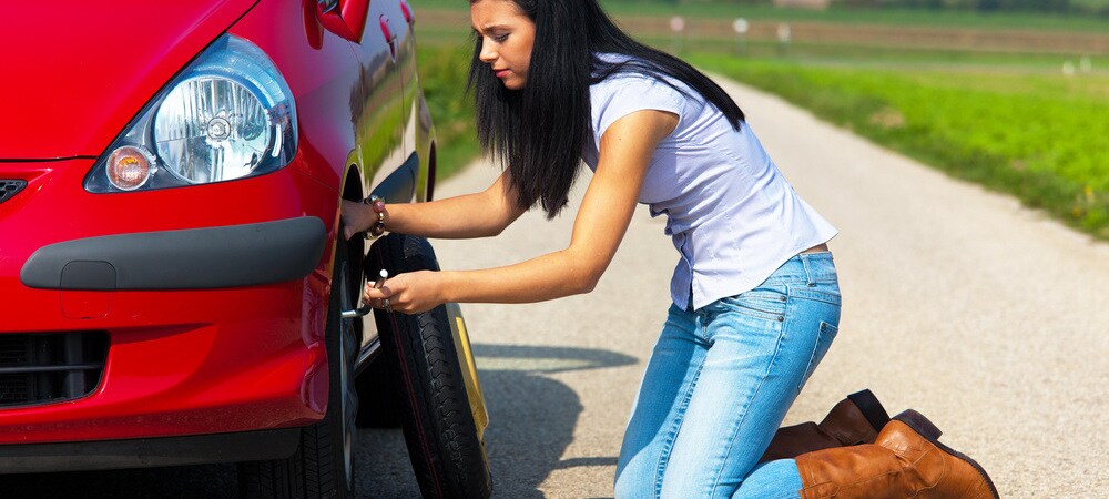 Woman with a flat tire on car.jpg