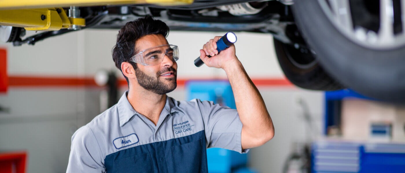 A Hyundai service tech inspecting a car