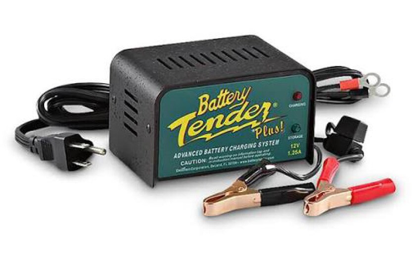 A high-quality battery maintainer connected to a parked vehicle.