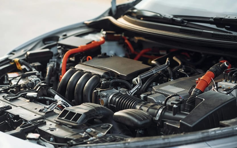 A driver looking concerned while trying to start a vehicle, emphasizing the frustration of a slow engine crank.