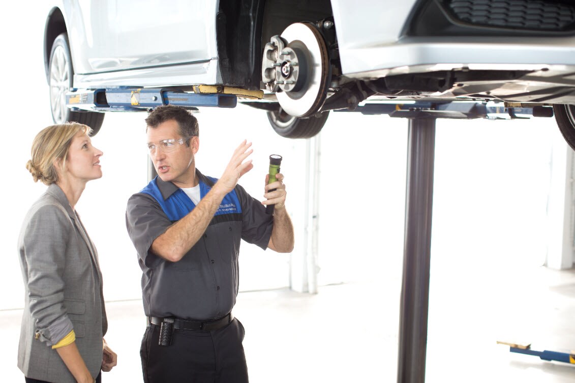 Subaru Service Tech Performing Brake Inspection with Owner discussing Brake Maintenance.jpg Image of Subaru Service Tech Performing Brake Inspection with Owner discussing Brake Maintenance