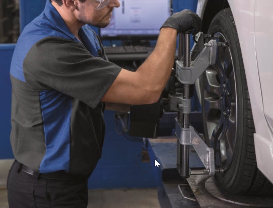 Tech mounting Subaru alignment equipment.jpg Tech mounting Subaru alignment equipment
