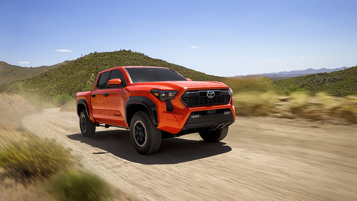 Orange 2025 Toyota Tacoma driving off-road