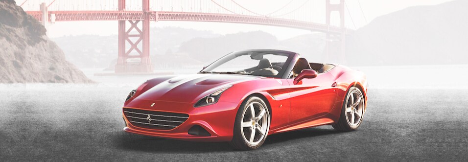 Red Ferrari California from driver side view in front of bridge