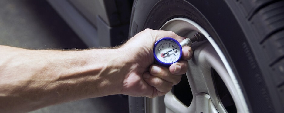 Checking tire-pressure man checking an audi tire pressure