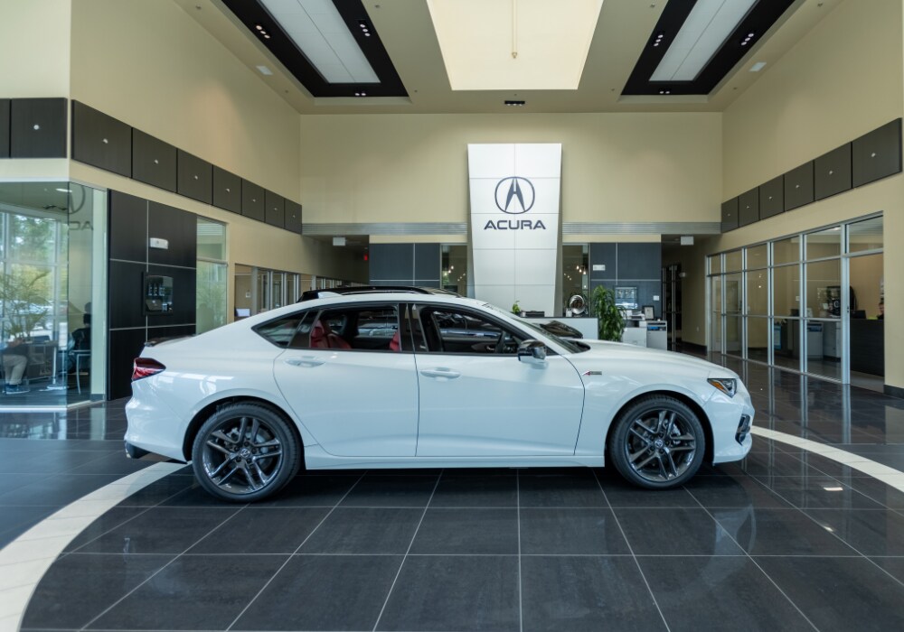 acura-for-sale-wilmington.png White Acura sedan parked inside the showroom of Flow Acura of Wilmington in North Carolina