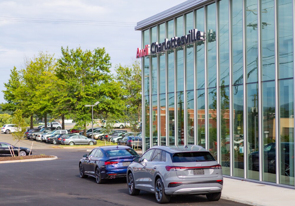 used-audi-cars-charlottesville.png Storefront of Audi Charlottesville dealership in Virginia. There is an Audi sedan and an Audi SUV parked in front of the dealership