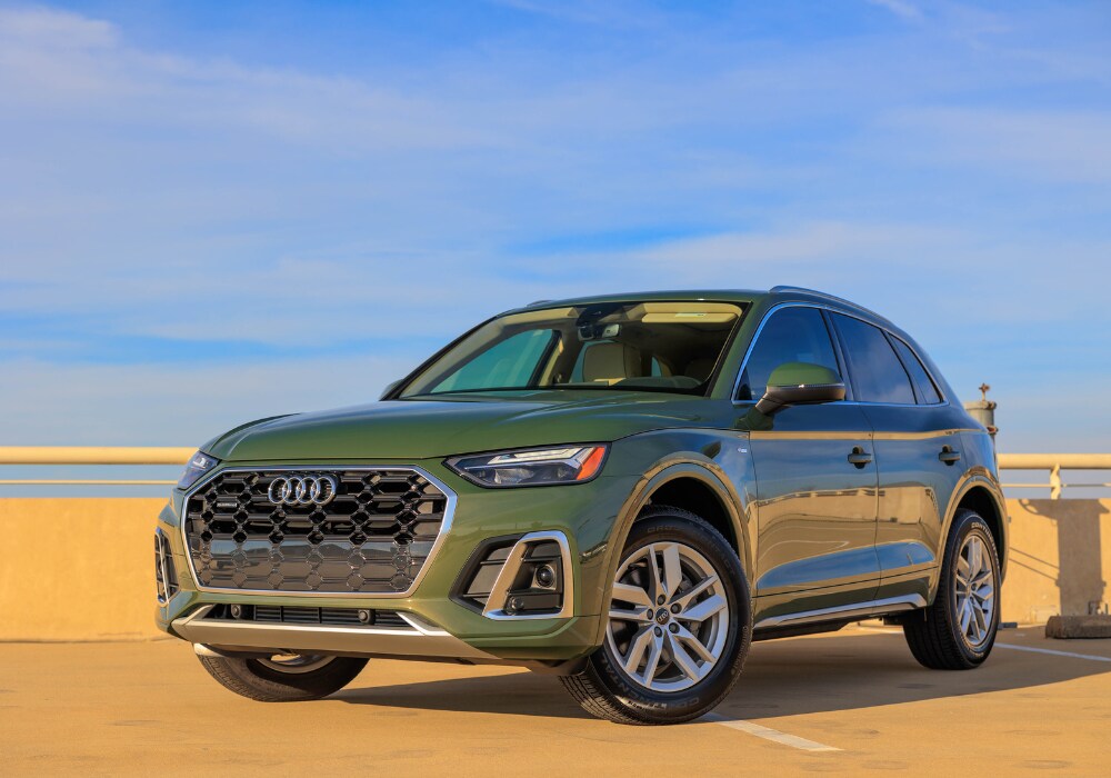 Green 2024 Audi Q5 SUV for sale with a blue sky in the background